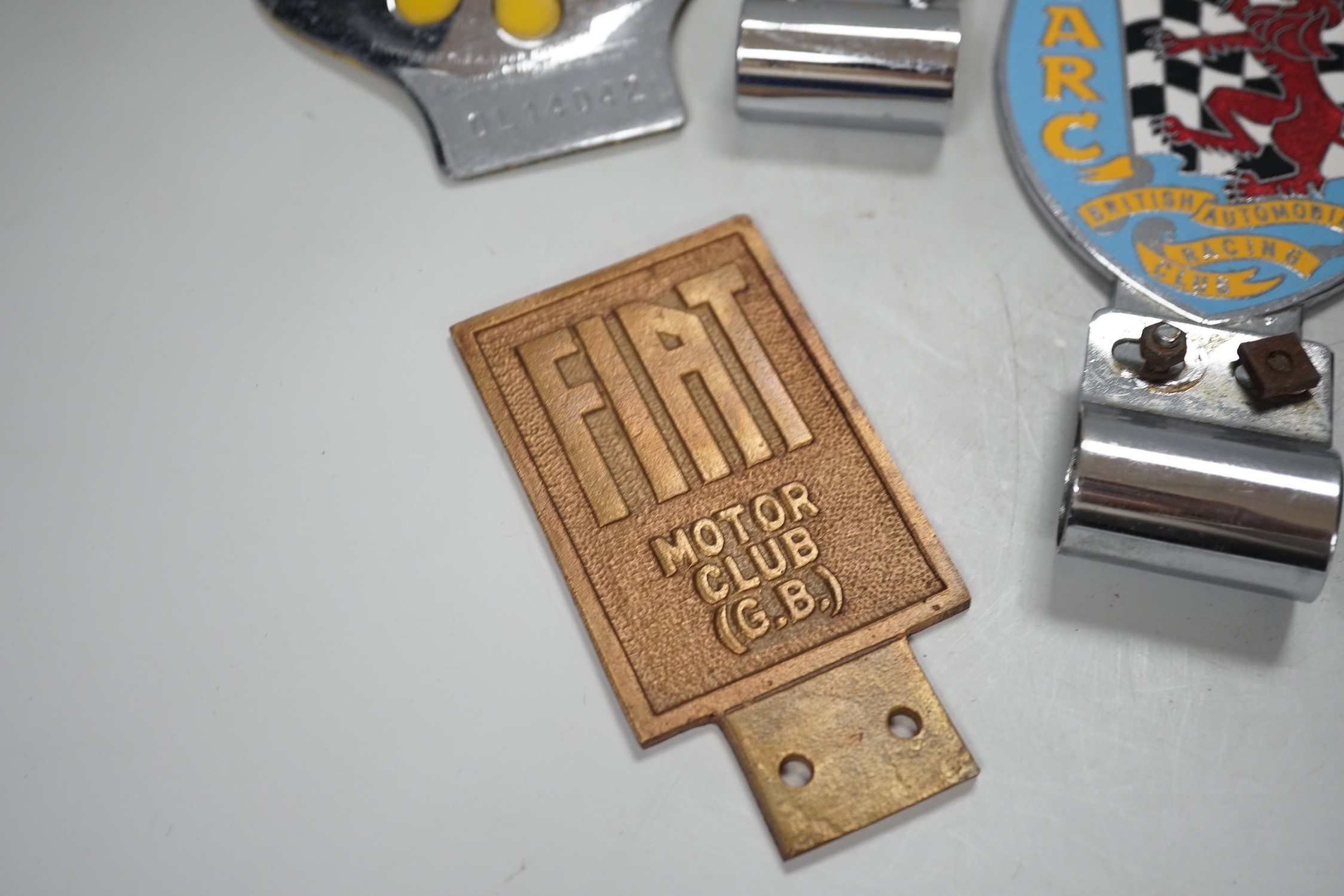 Seven car badges: Fiat motor club, British automobile racing club, MG club, the automobile club and three AA badges